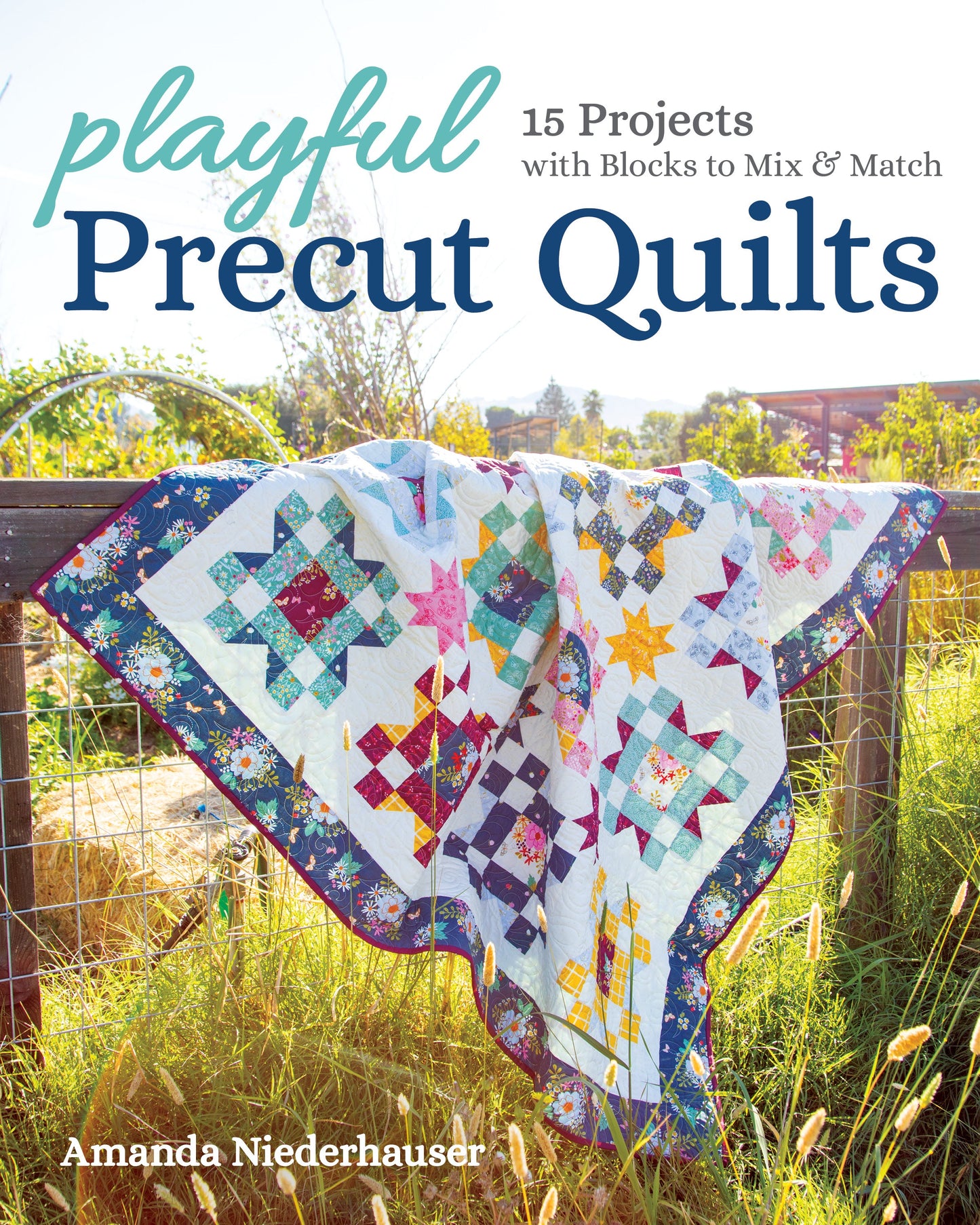 A colorful patchwork quilt hangs over a wooden fence in sunlight. The “Playful Precut Quilts Digital Download” by Stash Books offers 15 creative patterns with mix-and-match blocks for versatile quilting projects.