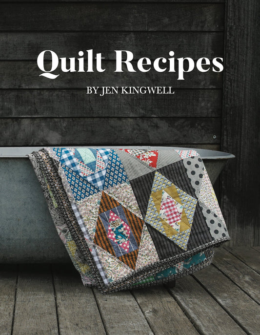 A vibrant patchwork quilt displayed on a vintage tub highlights "Quilt Recipes" by C&T Publishing—an inspiring book filled with creative ideas to enhance your next quilting project.