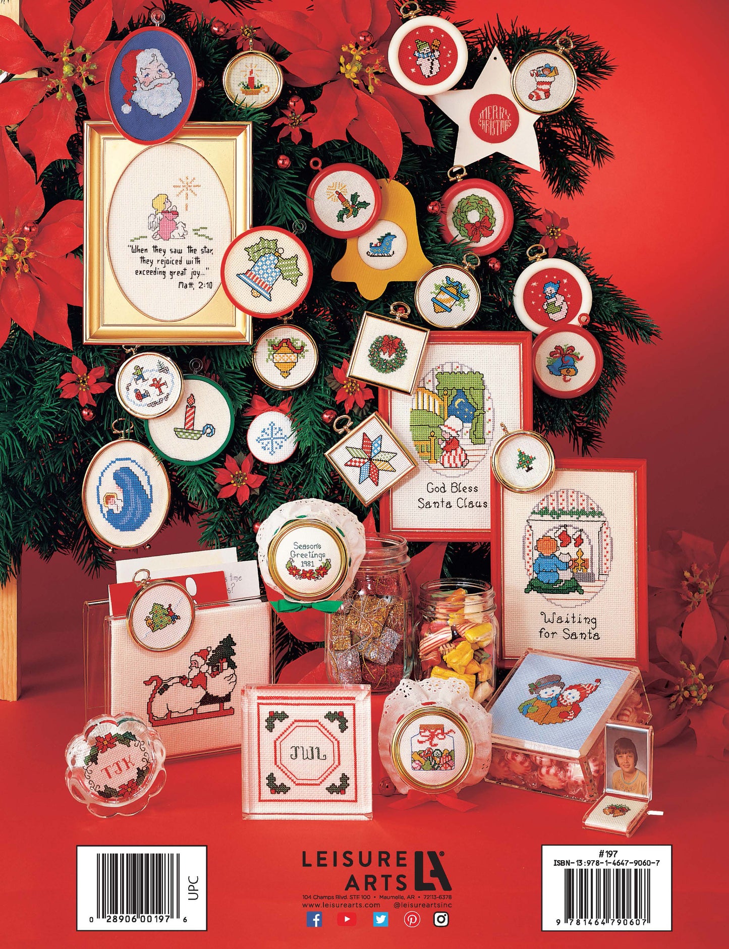 Christmas Stitchin' by Leisure Arts showcases beginner cross stitch Christmas designs—ornaments and cards with Santa, snowmen, and stars—displayed on a tree and red table surrounded by poinsettias and candy jars.