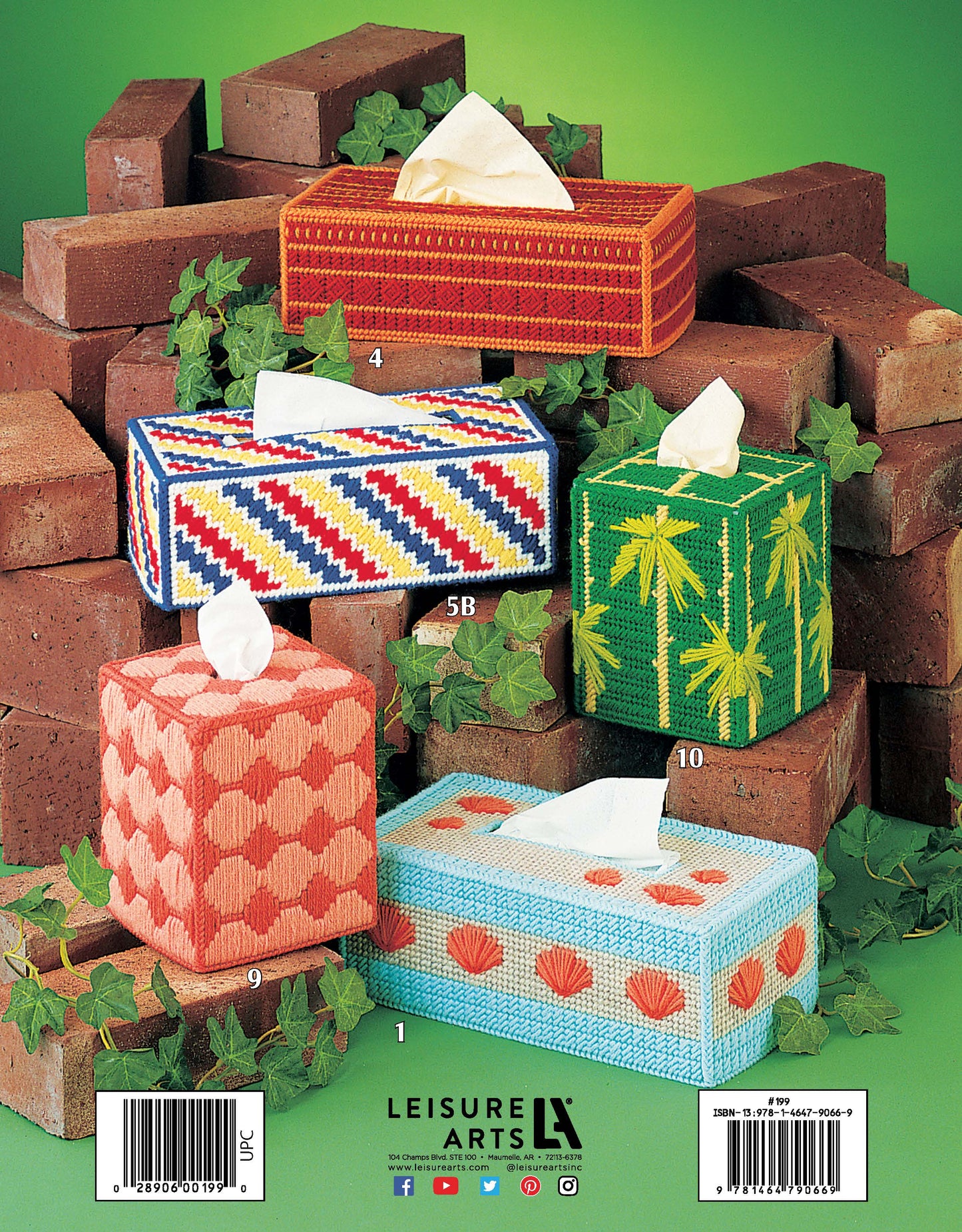 Four Leisure Arts "Tissue Box Covers for Plastic Canvas" with vibrant red chevrons, green leaves, orange fans, and pink circles are shown with tissues popping out, set against stacked bricks and lush green ivy.