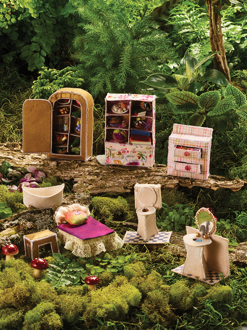 The Tiny Worlds in Fabric Digital Download by C&T Publishing features miniature dollhouse furniture, like wardrobes and beds, artfully arranged on moss and bark for a whimsical fairy house scene blending nature with tiny home décor.
