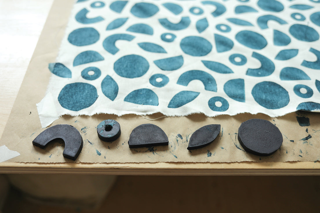Contemporary Patchwork by Stash Books features blue geometric patterns created with black ink stamps, showcasing surface design techniques such as semicircles, circles, and leaves on fabric.