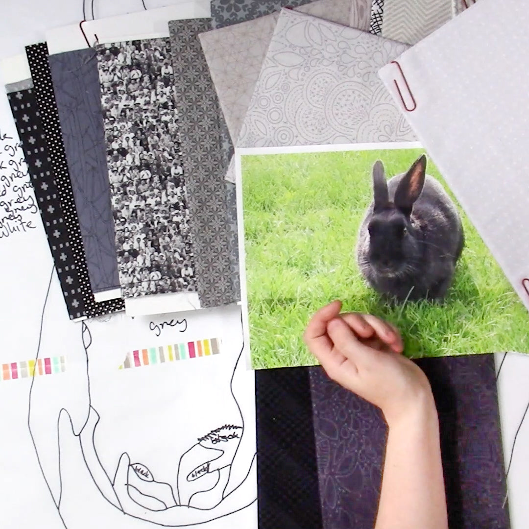 A hand displays a photo of a gray rabbit on grass with fabric swatches, suggesting plans for the Design Your Own Paint By Numbers Quilt: Pet Portraits by Creative Spark. A black line drawing on white paper rests underneath.