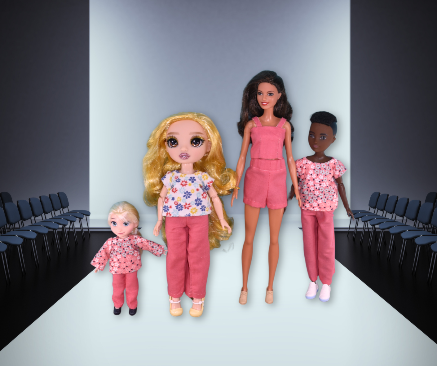 Four dolls in pink outfits, made using Creative Spark’s “How to Alter Doll Clothes Patterns,” stand on a dimly lit runway with empty chairs. Two larger dolls are centered, two smaller at the ends, each showcasing unique pattern alterations.