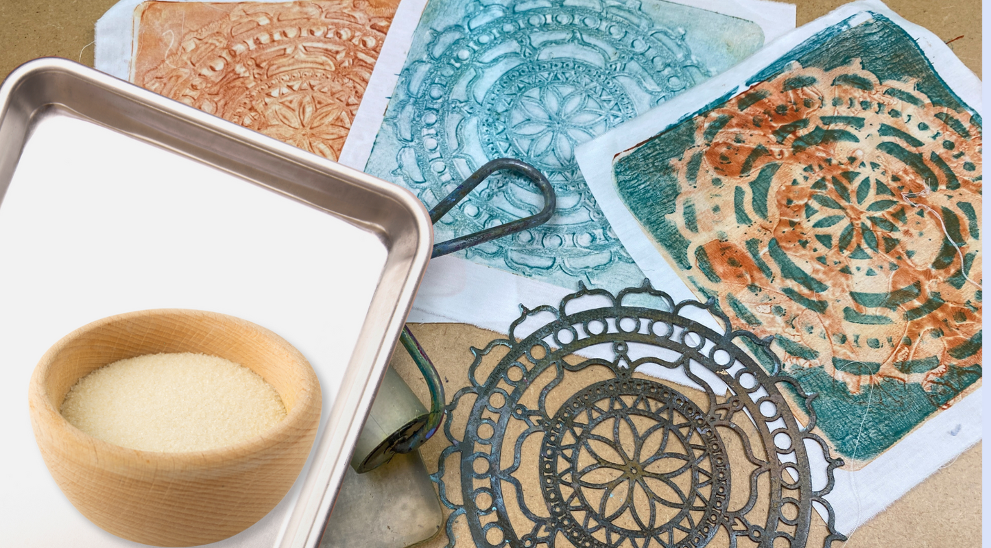 A wooden bowl of gelatin powder sits beside printing tools, metal stencils, and vibrant mandala prints—perfect for custom fabric panels using the Creative Spark Make Your Own Gel Printing Plate.