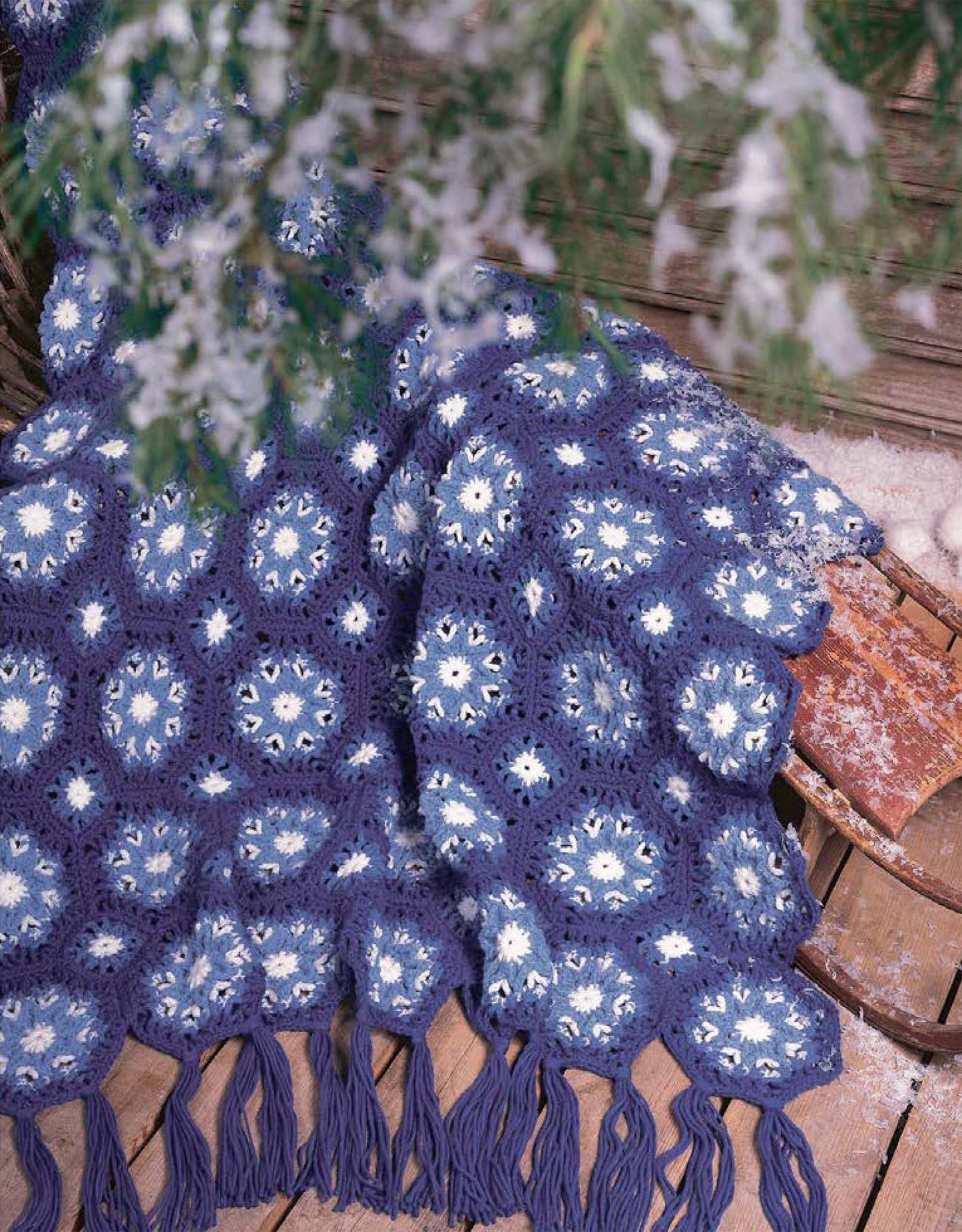 The Afghans for All Seasons Crochet Book 2 by Leisure Arts features beginner-friendly patterns, including cozy crocheted afghans in blue, white, and dark purple—perfect seasonal throws for winter décor.