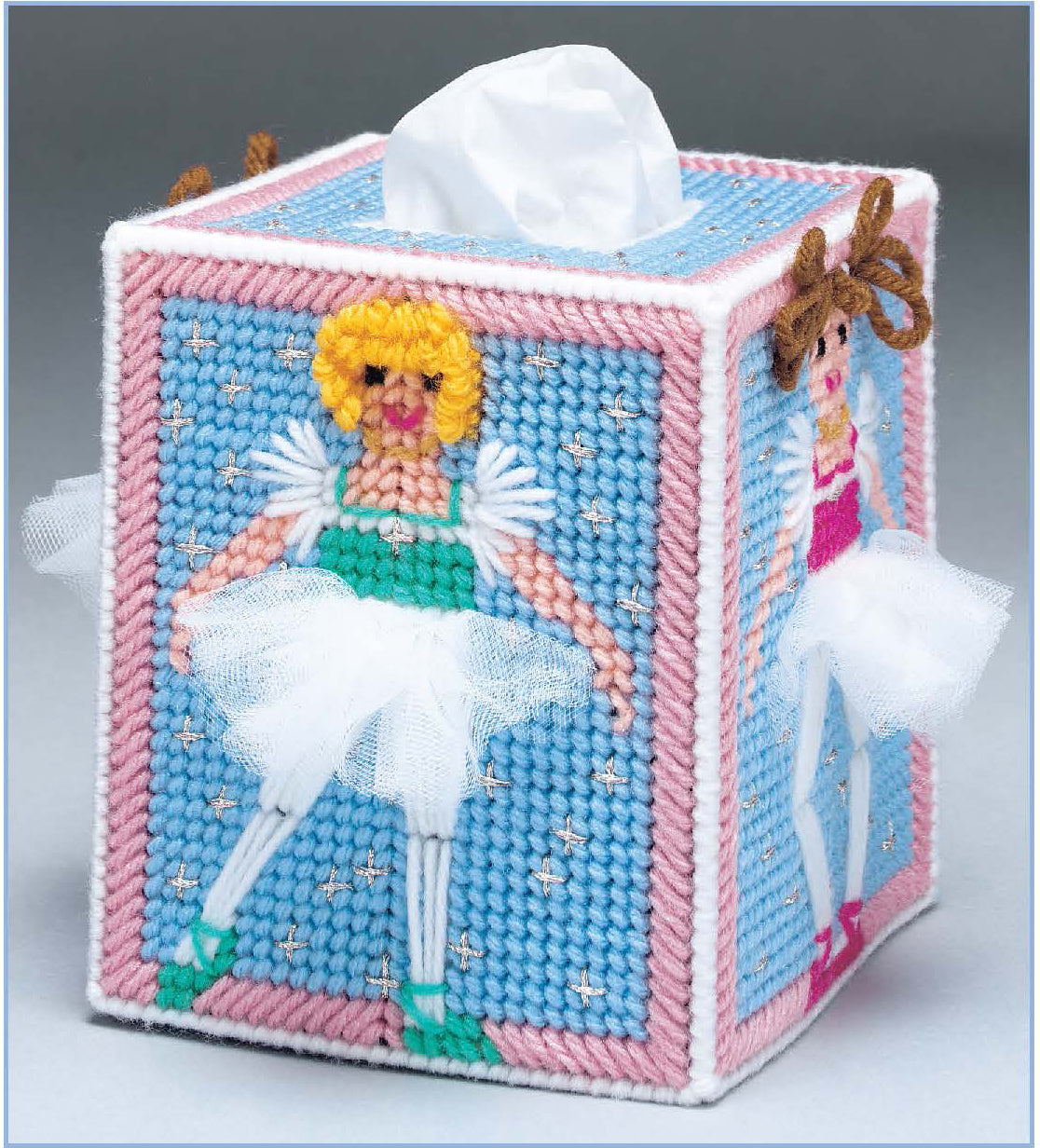 The Room by Room Plastic Canvas Tissue Box Covers Digital Download by Leisure Arts features beginner-friendly needlepoint ballerinas in white tutus on blue backgrounds, bordered with pink, white, and blue yarn.