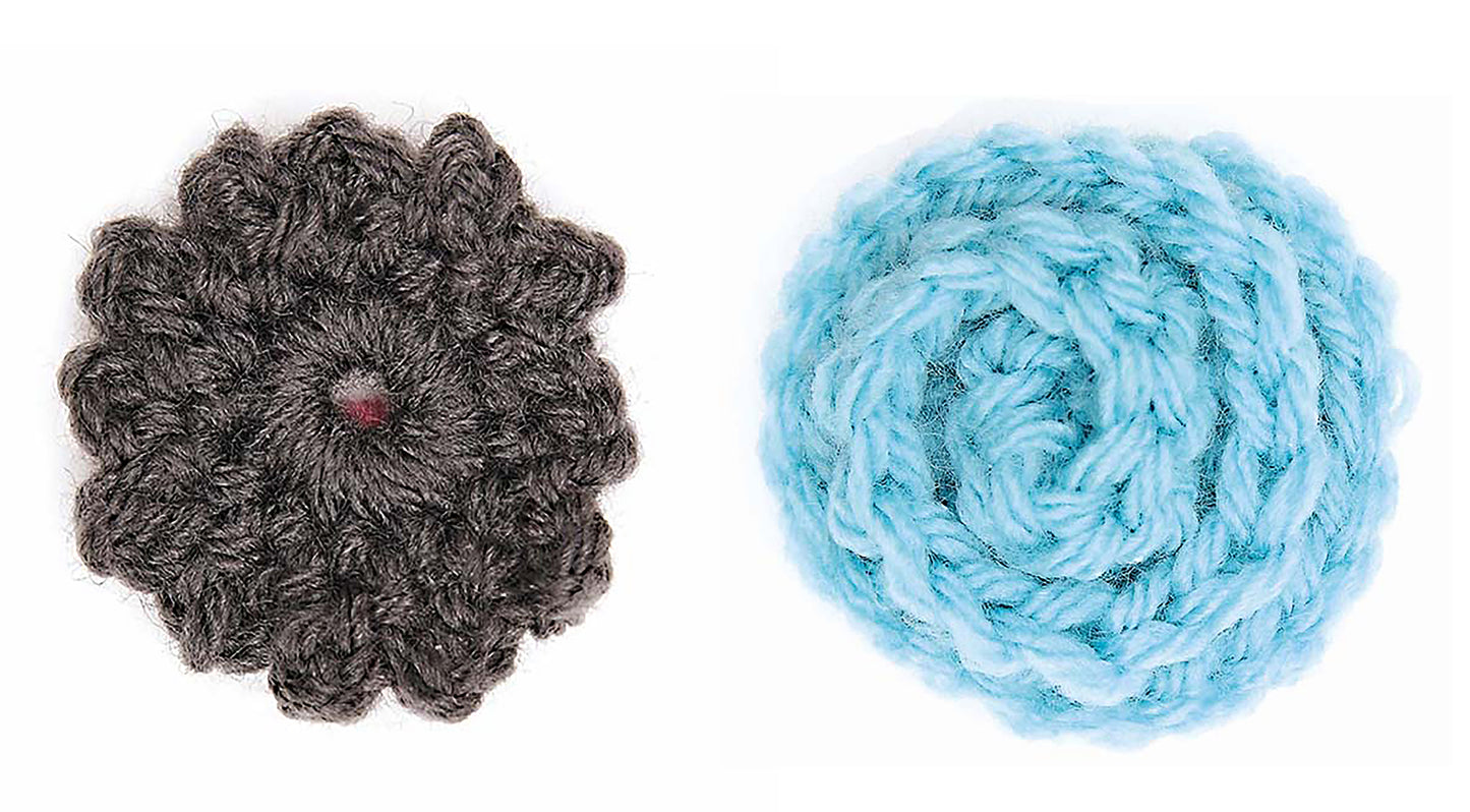 Two crocheted flowers—one dark gray with a visible center, one light blue with a spiral pattern—are shown on white. Ideal for beginner crafters, Crochet Embellishments by Leisure Arts offers creative inspiration.