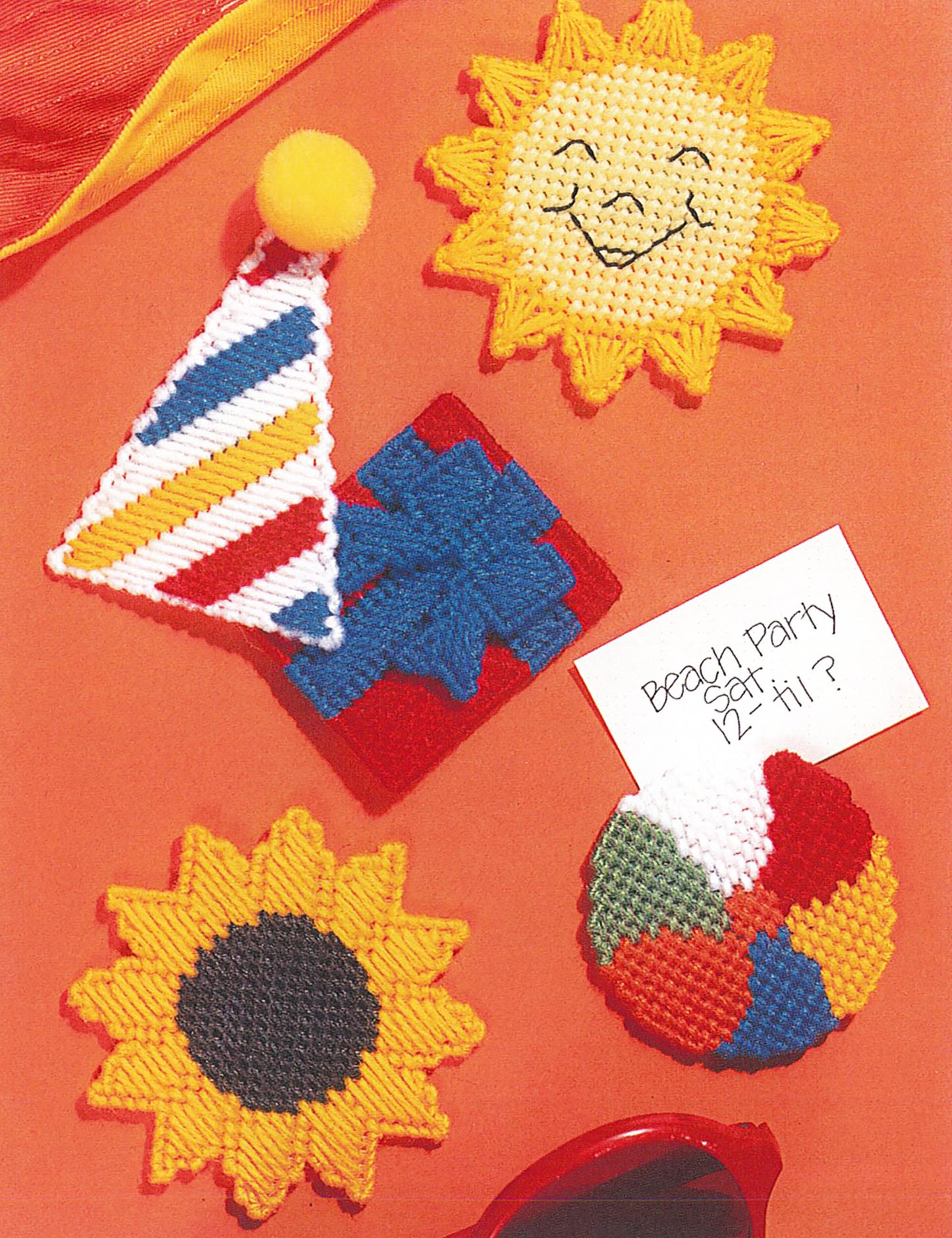 Five playful, handcrafted magnets from Leisure Arts’ “Magnets Thru Out the Year” feature sunflowers, a smiley sun, beach ball, present, and party hat—perfect plastic canvas designs—for festive decorating.