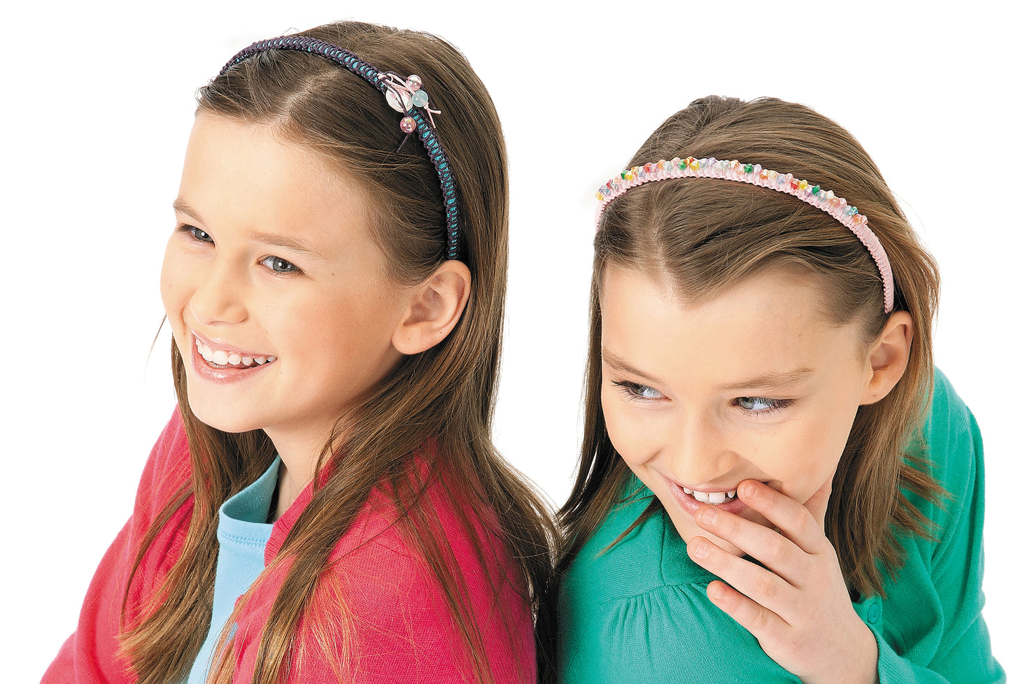 Two smiling girls with long brown hair sit back-to-back. One wears a pink cardigan; the other shows off beginner jewelry—a colorful beaded headband from Knots & Beads—Easy Jewelry to Make & Share! by Leisure Arts. White background.