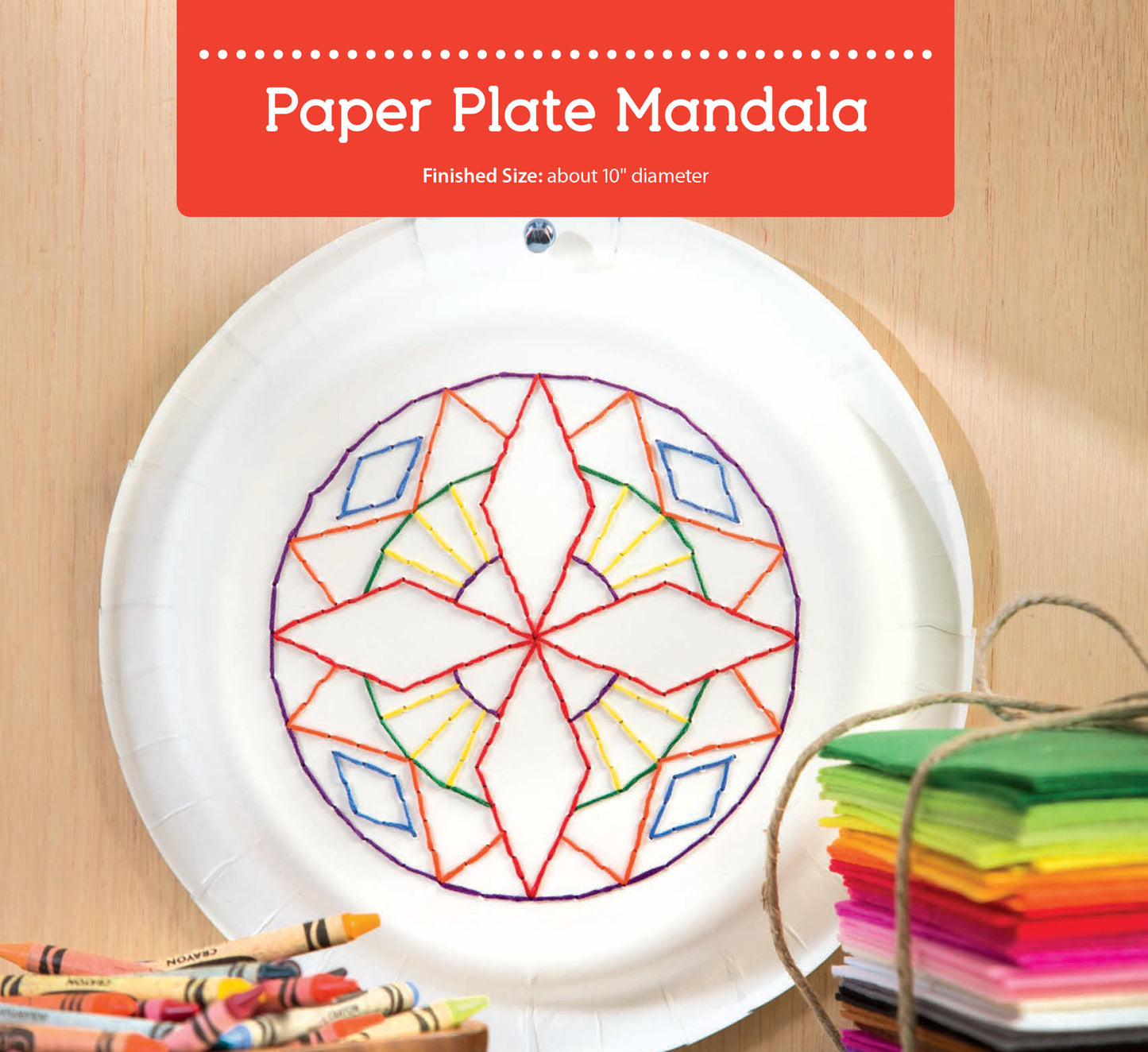 A white paper plate with a colorful mandala stitched in yarn is displayed on wood, with crayons and tissue paper in front. After-School Kids' Crafts by Leisure Arts offers perfect easy craft projects for kids.