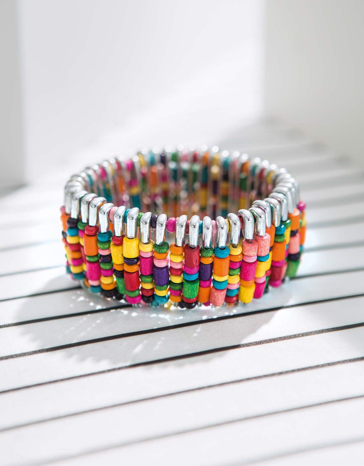 The Quick Fun Jewelry Digital Download by Leisure Arts features wide stretch bracelets with multicolored wooden beads in pink, orange, yellow, green, teal, and purple linked by silver—great for customizable or beginner jewelry crafts.