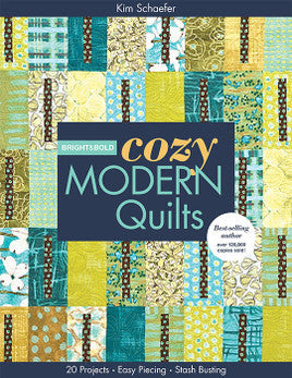 Book cover for Bright & Bold Cozy Modern Quilts Print-on-Demand Edition by C&T Publishing, featuring a vibrant patchwork quilt in blue, green, and yellow with floral and geometric patterns—ideal for cozy modern home decor.