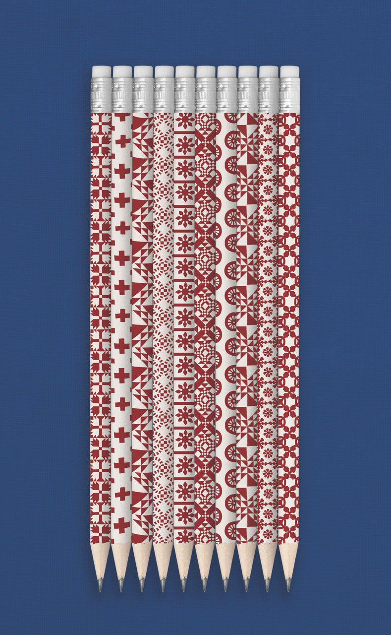 Ann Hazelwood's Red & White Quilty Pencils by C&T Publishing, featuring Ukrainian embroidery designs, are arranged vertically on a blue background—creating a bold gift for quilt lovers.