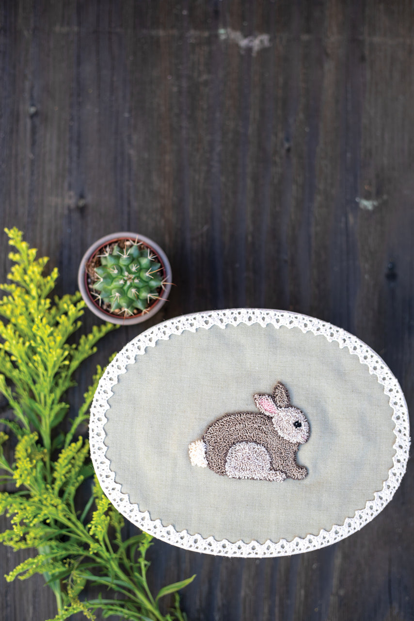 Jump Into Punch Needle by C&T Publishing features an embroidered bunny on a lace-trimmed linen round—an ideal fiber art project for beginners, beautifully displayed with floral accents and perfect for creative home decor.