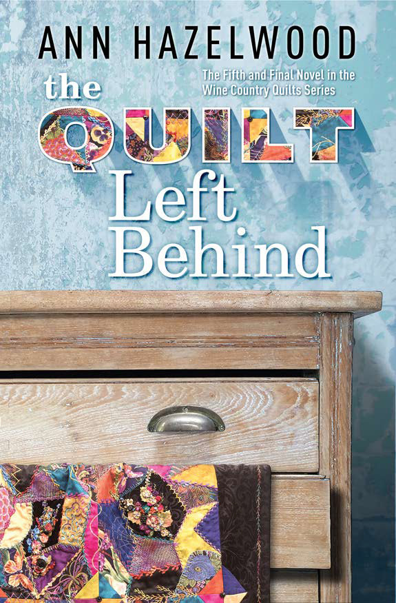 Book cover for The Quilt Left Behind from the Wine Country Quilts Series Collection by C&T Publishing, showing a colorful quilt on a wooden drawer against a textured blue wall—ideal for fans of the series.