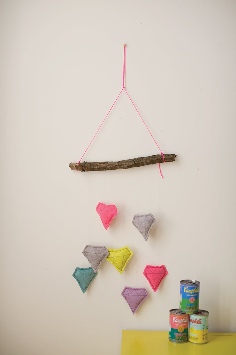 Create a playful wall hanging with My Sewing Workshop by FunStitch Studio, using bright pink string and colorful felt diamonds—an inspiring kids’ craft kit. Display your masterpiece next to cans on a yellow table for added charm!.
