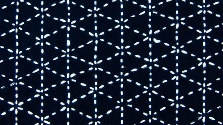 Woven Bamboo: Moyouzashi (Sashiko Starter Series #2) by Creative Spark features white geometric embroidery in star and diamond motifs on dark blue fabric, reflecting traditional Sashiko patterns often taught in beginner classes.