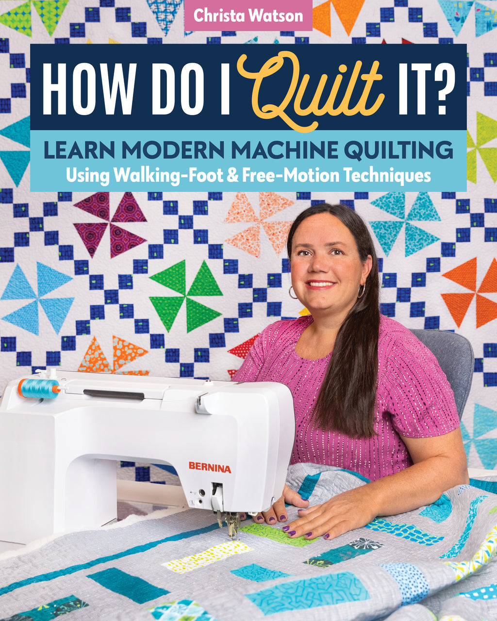 A woman in a pink top quilts a vibrant patchwork using modern machine quilting and walking-foot techniques. Behind her hang blue and green geometric quilts. She holds the Stash Books title, How Do I Quilt It?.