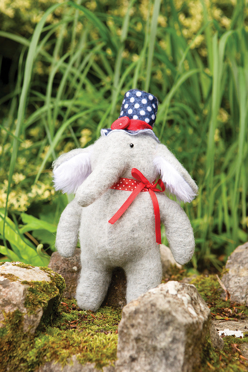 The Instant Softies by Stash Books features a cute gray handmade stuffed elephant with white ears, a red ribbon, and a blue polka-dot hat—perfect inspiration for beginner soft toy crafts in your collection.