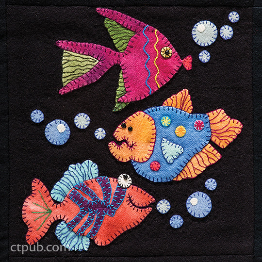 Three colorful, embroidered fish from C&T Publishing’s Summertime Sampler Print-on-Demand Edition swim diagonally across a black background, blowing blue bubbles. Each fish features unique patterns, decorative stitching, and sewn-on embellishments—offering a delightful quilt pattern ideal for a summer sampler or wool appliqué project.