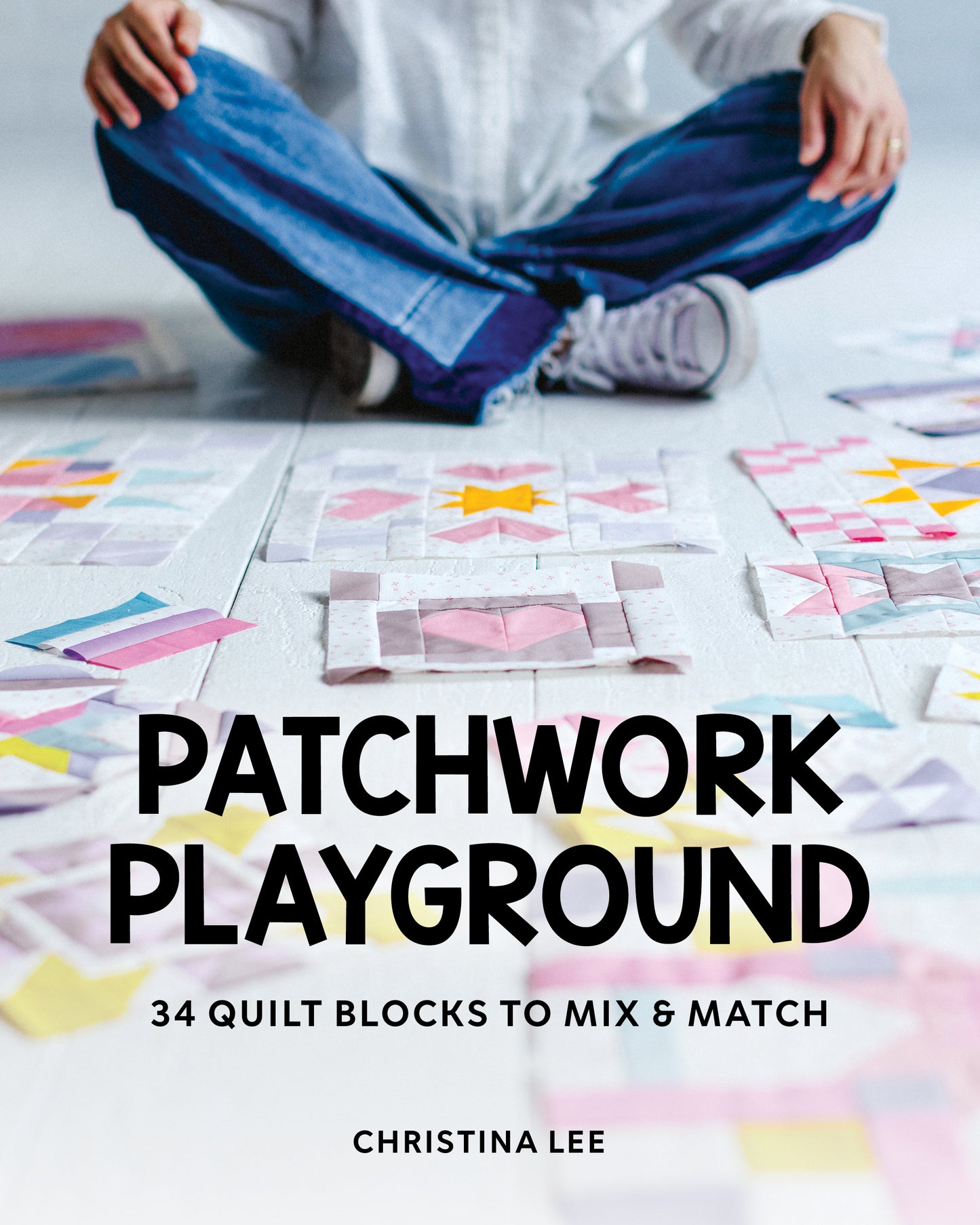 A person sits cross-legged on the floor with colorful quilt blocks. The book title "Patchwork Playground" by Stash Books is displayed boldly, capturing a playful moment for patchwork lovers.