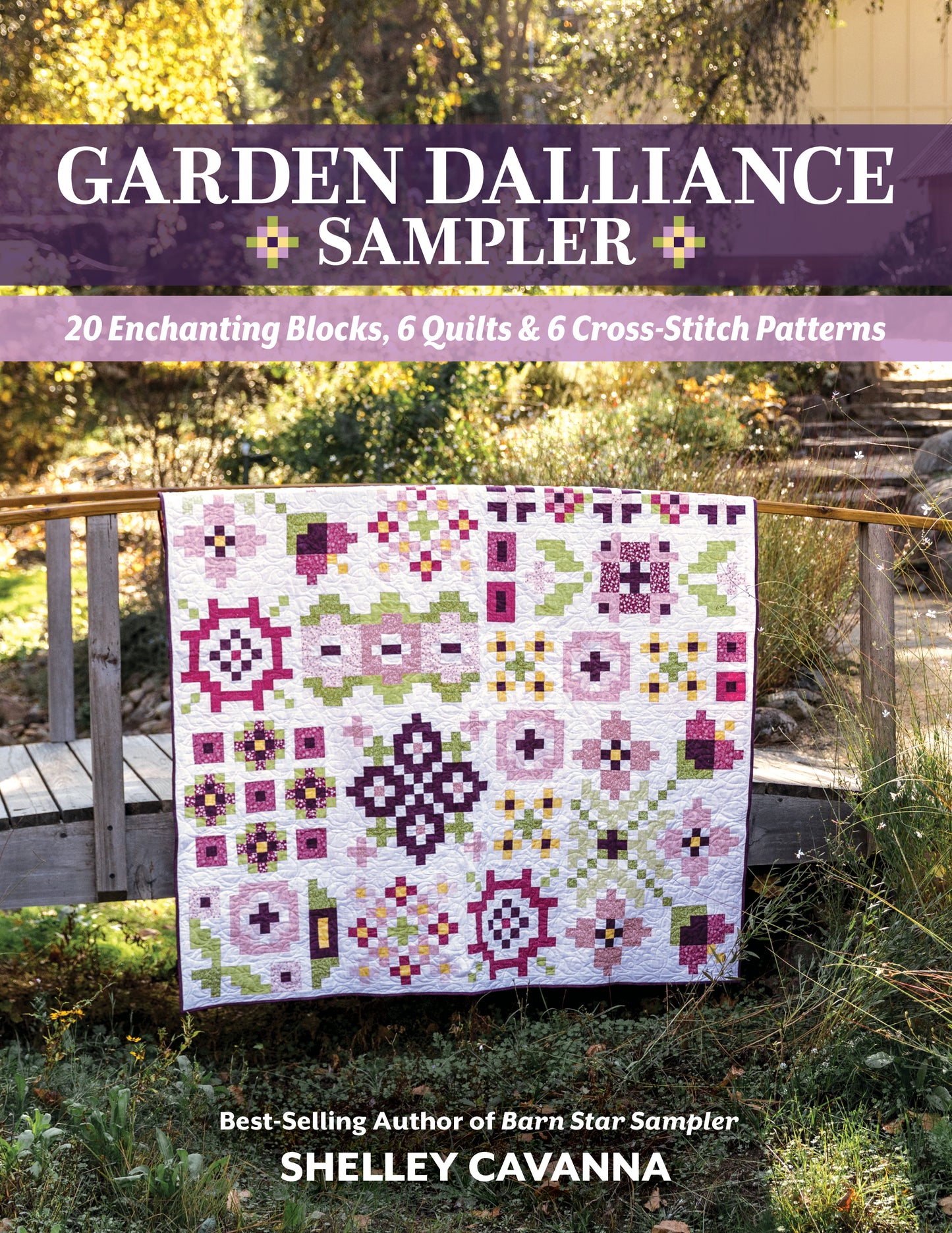 The Garden Dalliance Sampler by C&T Publishing, featuring vibrant pink, purple, green, and white geometric patterns, is draped over a wooden bridge in a sunlit garden—perfect inspiration for your next quilting project.