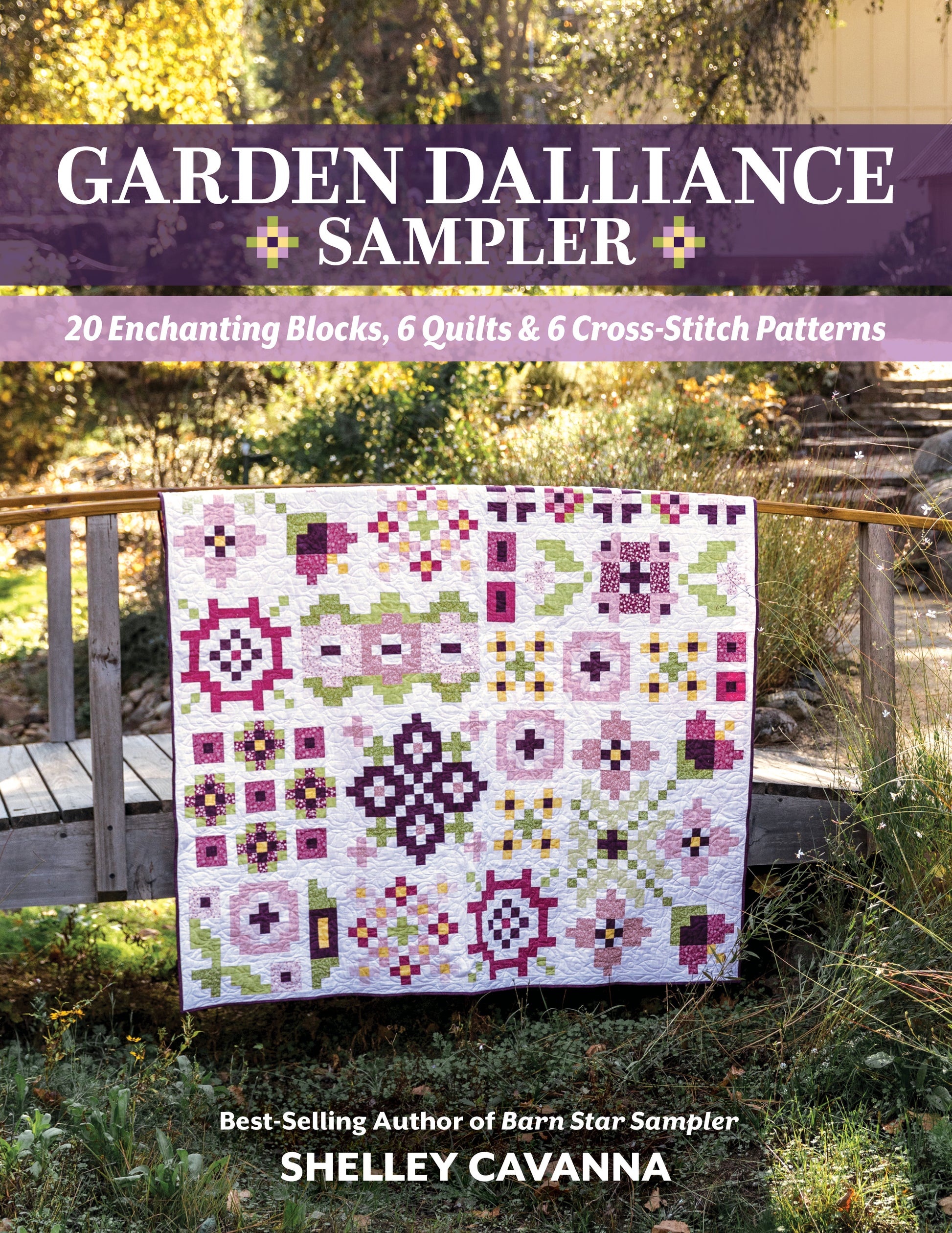 The Garden Dalliance Sampler by C&T Publishing, featuring vibrant pink, purple, green, and white geometric patterns, is draped over a wooden bridge in a sunlit garden—perfect inspiration for your next quilting project.