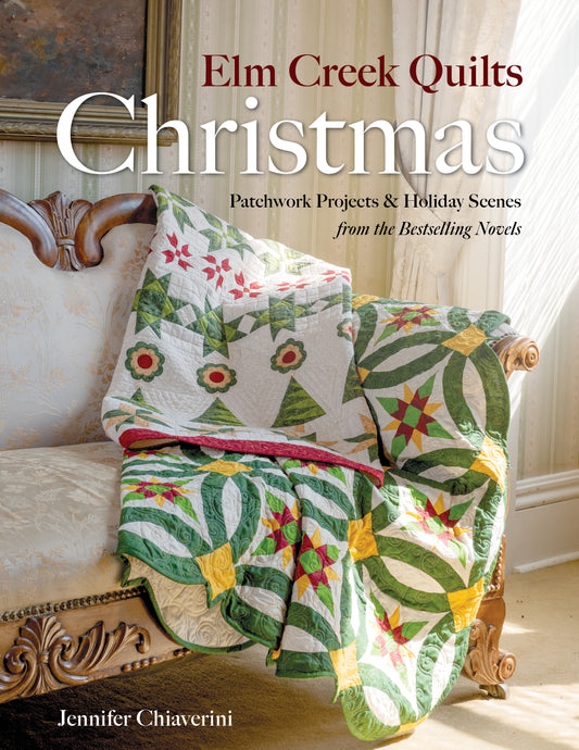 Book cover for Elm Creek Quilts Christmas by C&T Publishing features two colorful patchwork quilts on a cream chair, perfect for holiday quilting projects. Sunlight streams through a nearby window.