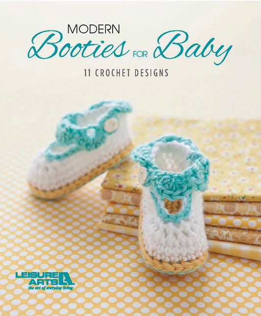 Cover of "Modern Booties for Baby" by Leisure Arts, a crochet pattern book with beginner bootie designs, showing handmade white and turquoise baby booties on yellow patterned fabric.