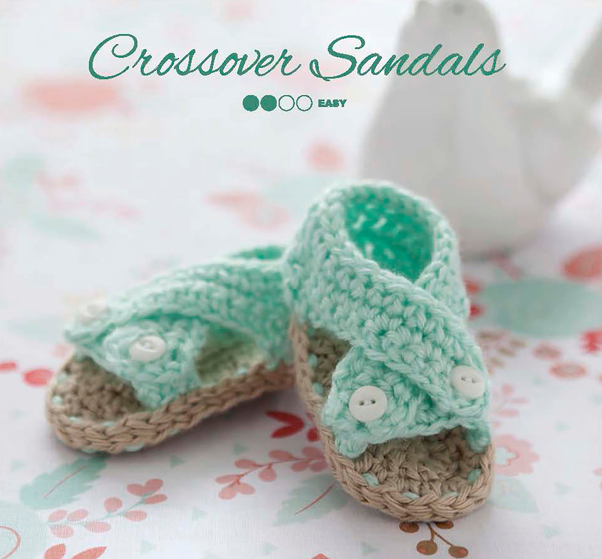 Modern Booties for Baby by Leisure Arts feature mint green crossover straps and white buttons, displayed on a light floral-patterned background with "Crossover Sandals" and "beginner crochet" above these adorable designs.