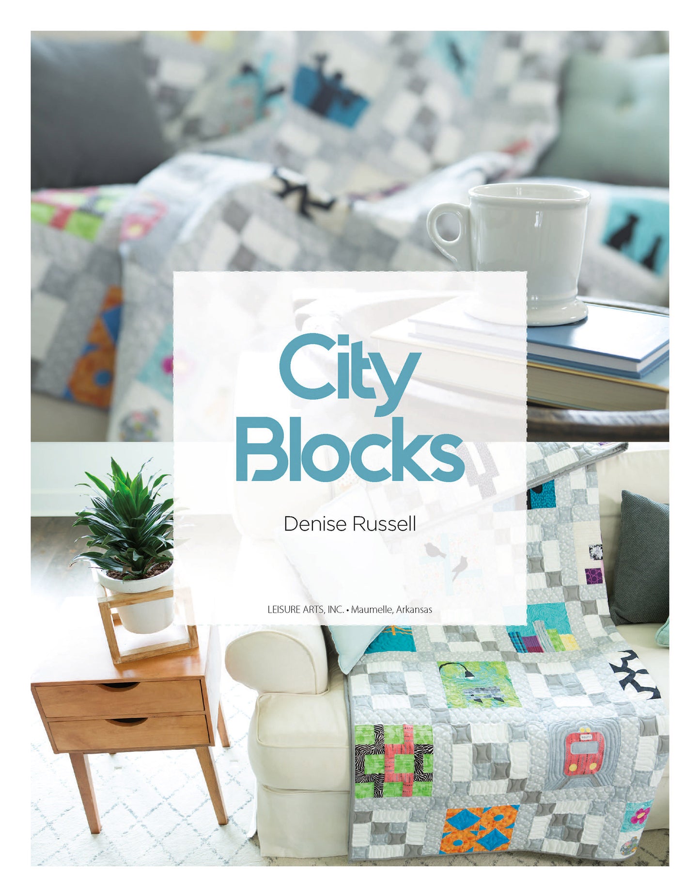 A light gray quilt made with "City Blocks—32 Pieced and Applique Blocks Portraying City Life Digital Download" by Leisure Arts drapes a white sofa, surrounded by a wooden side table, plant, books, and mug. Text: City Blocks, Denise Russell.
