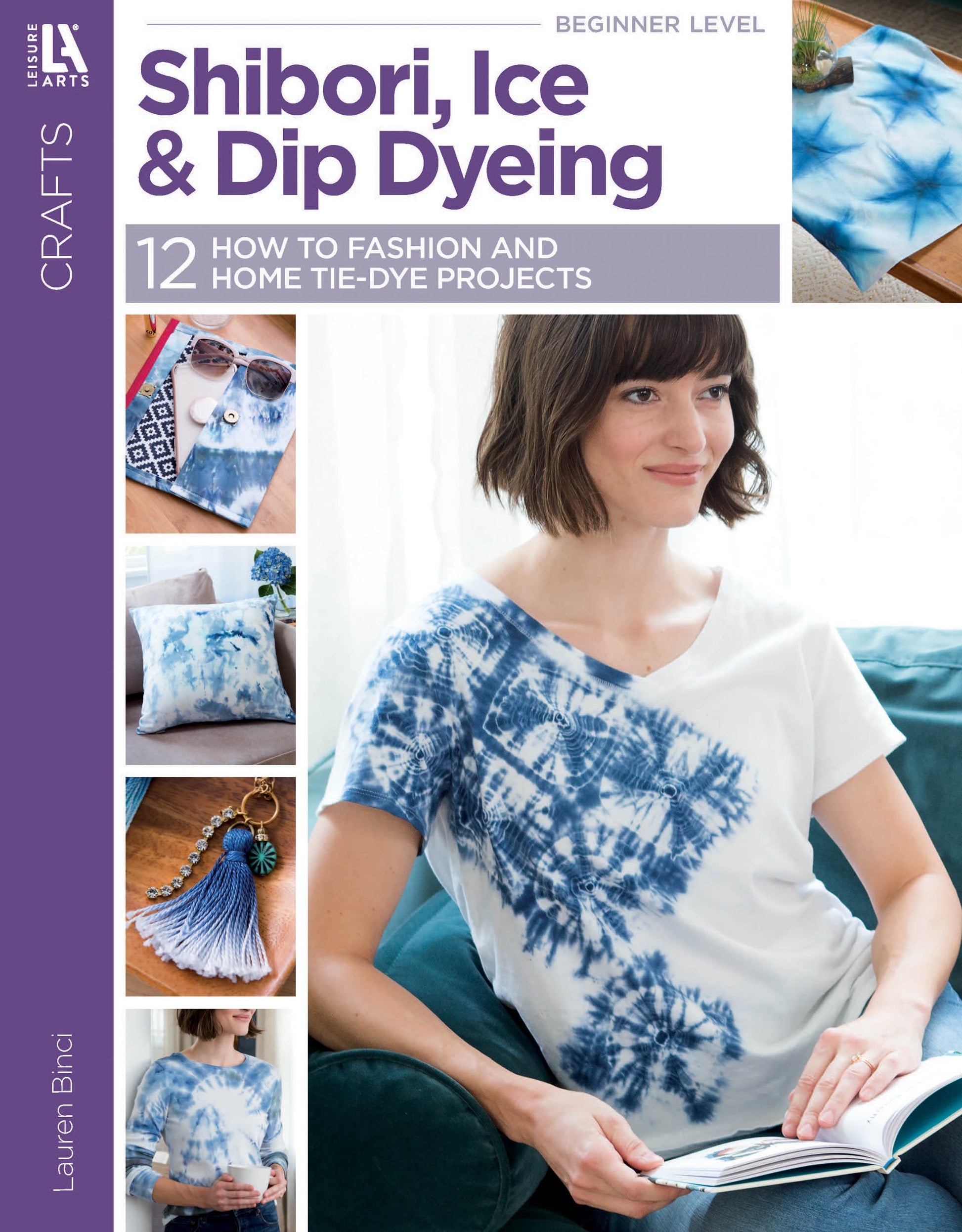 A smiling woman in a white and blue tie-dye shirt holds "Shibori, Ice & Dip Dyeing" by Leisure Arts, a book featuring beginner-friendly dyeing projects on natural fibers like shirts, napkins, and tassels.