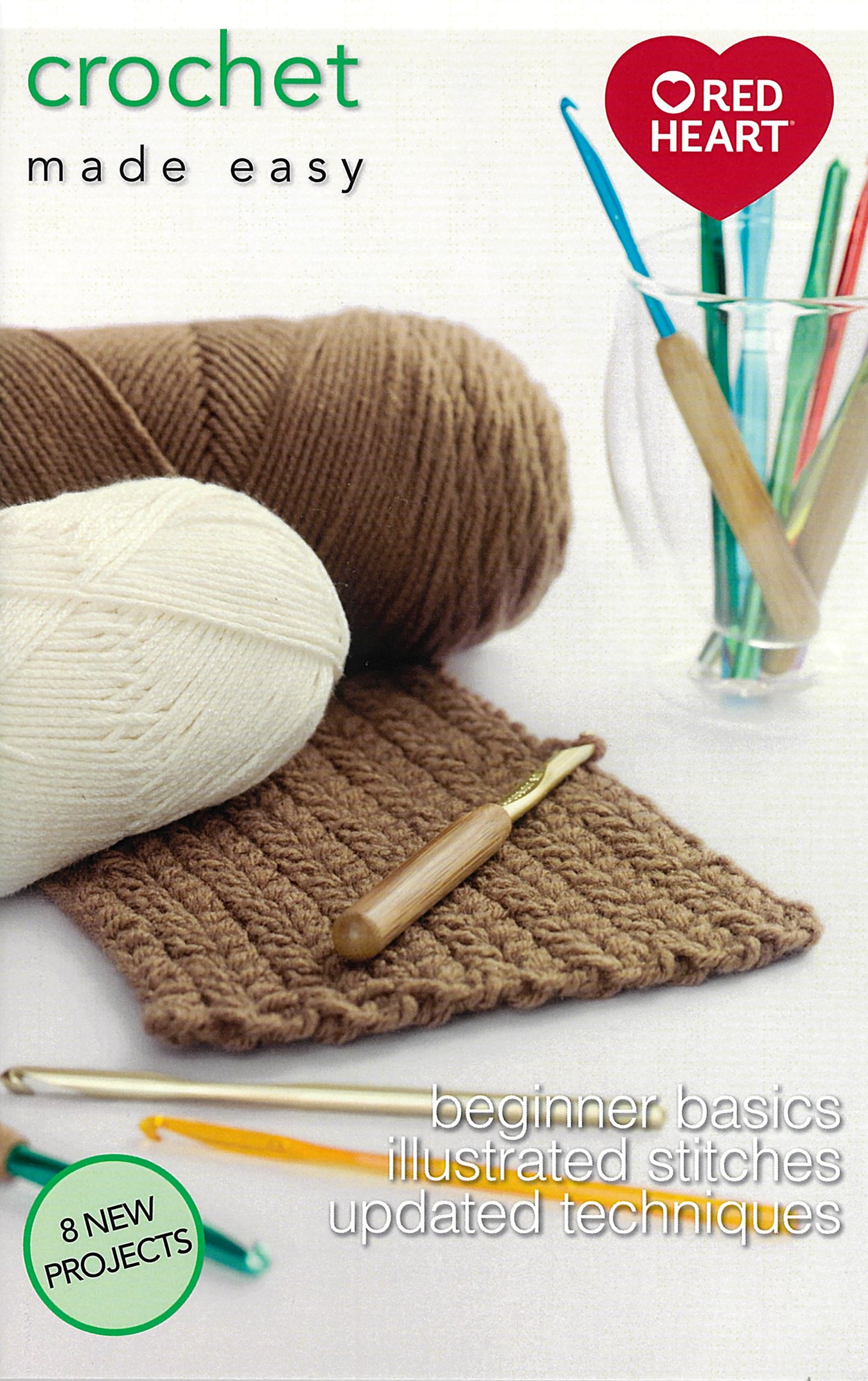 The cover of Crochet Made Easy by Leisure Arts features brown and white yarn, three crochet hooks, a swatch, a glass with hooks, and text highlighting beginner basics and 8 projects.