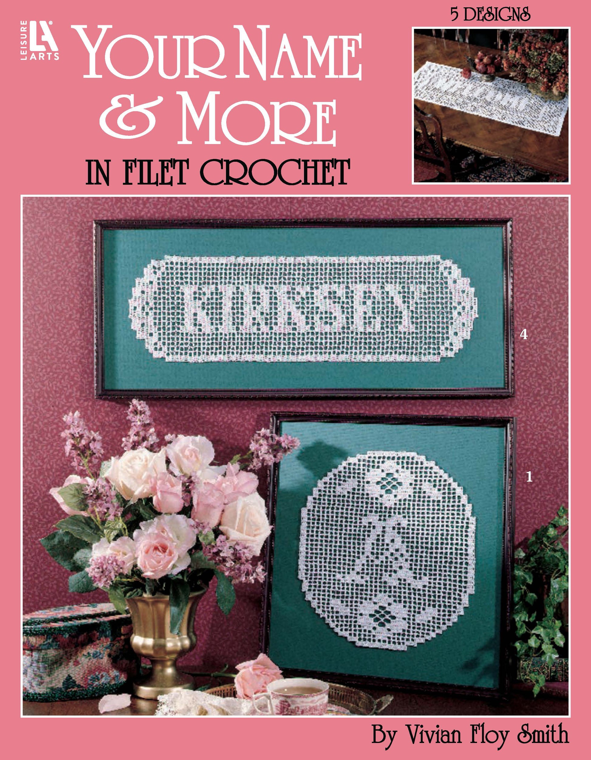 Digital cover of “Your Name & More in Filet Crochet Digital Download” by Leisure Arts showcases two framed filet crochet name designs, embellished with floral accents and displayed atop a delicate lace table runner. Ideal for family name crochet projects, these patterns are designed for use with bedspread weight cotton yarn.