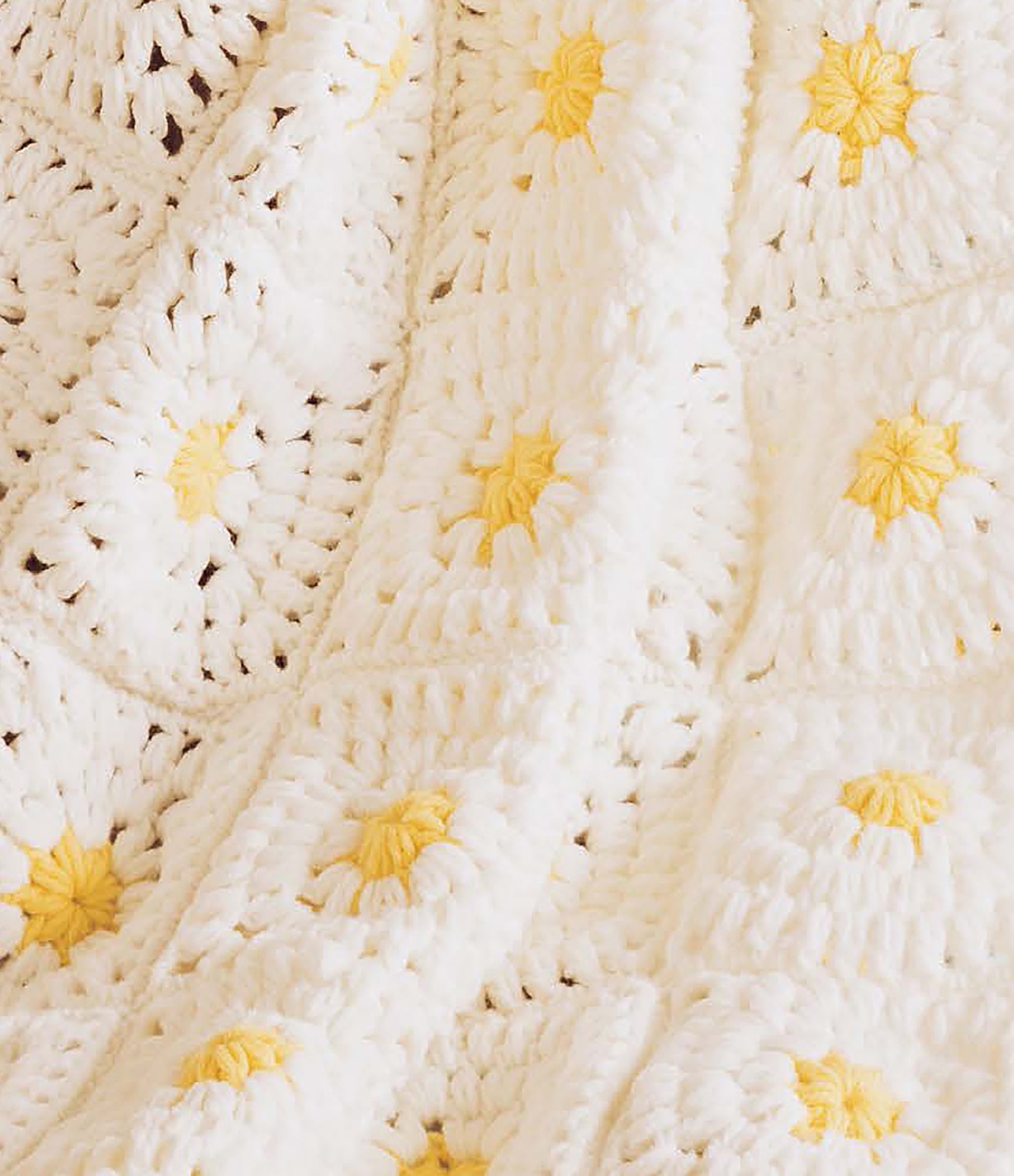A cozy, soft crocheted blanket from Leisure Arts' "Baby Afghans to Knit and Crochet" features white granny squares, each with a yellow flower-like center, showcasing timeless crochet designs.