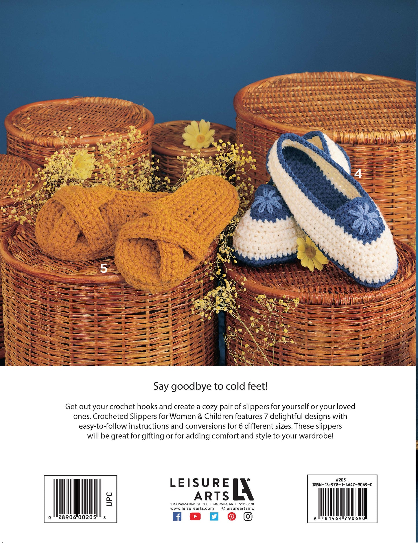 Two pairs of Leisure Arts Crocheted Slippers for Women & Children—one mustard yellow, one white with blue accents—rest on woven baskets with yellow flowers, standing out against a solid teal background.