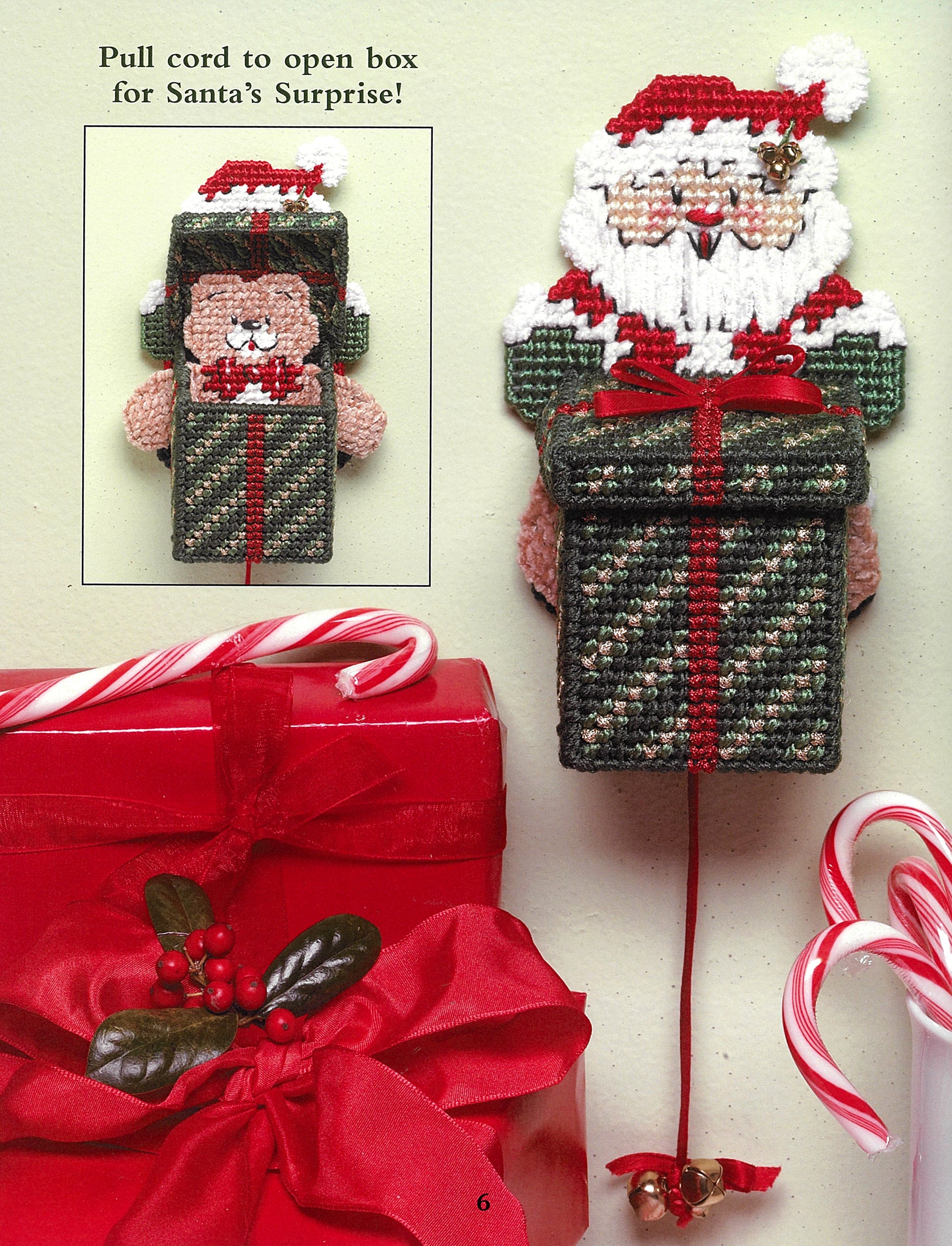The "Santa, Bears, & Bells in Plastic Canvas" by Leisure Arts is a beginner-friendly decorative wall hanging for holiday crafts, featuring Santa with a green and red box, ribboned gift box, and candy canes for festive charm.
