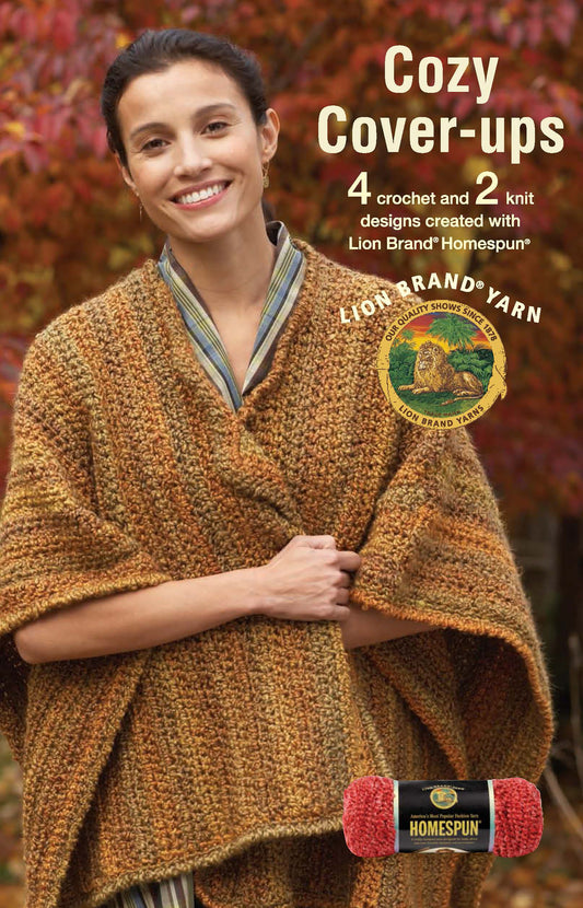 A smiling woman outdoors wears a brown, textured crocheted wrap. Text: Cozy Cover-Ups—4 crochet & 2 knit patterns for scarves and shawls made with Lion Brand Homespun yarn by Leisure Arts. Digital download. A red skein appears below.