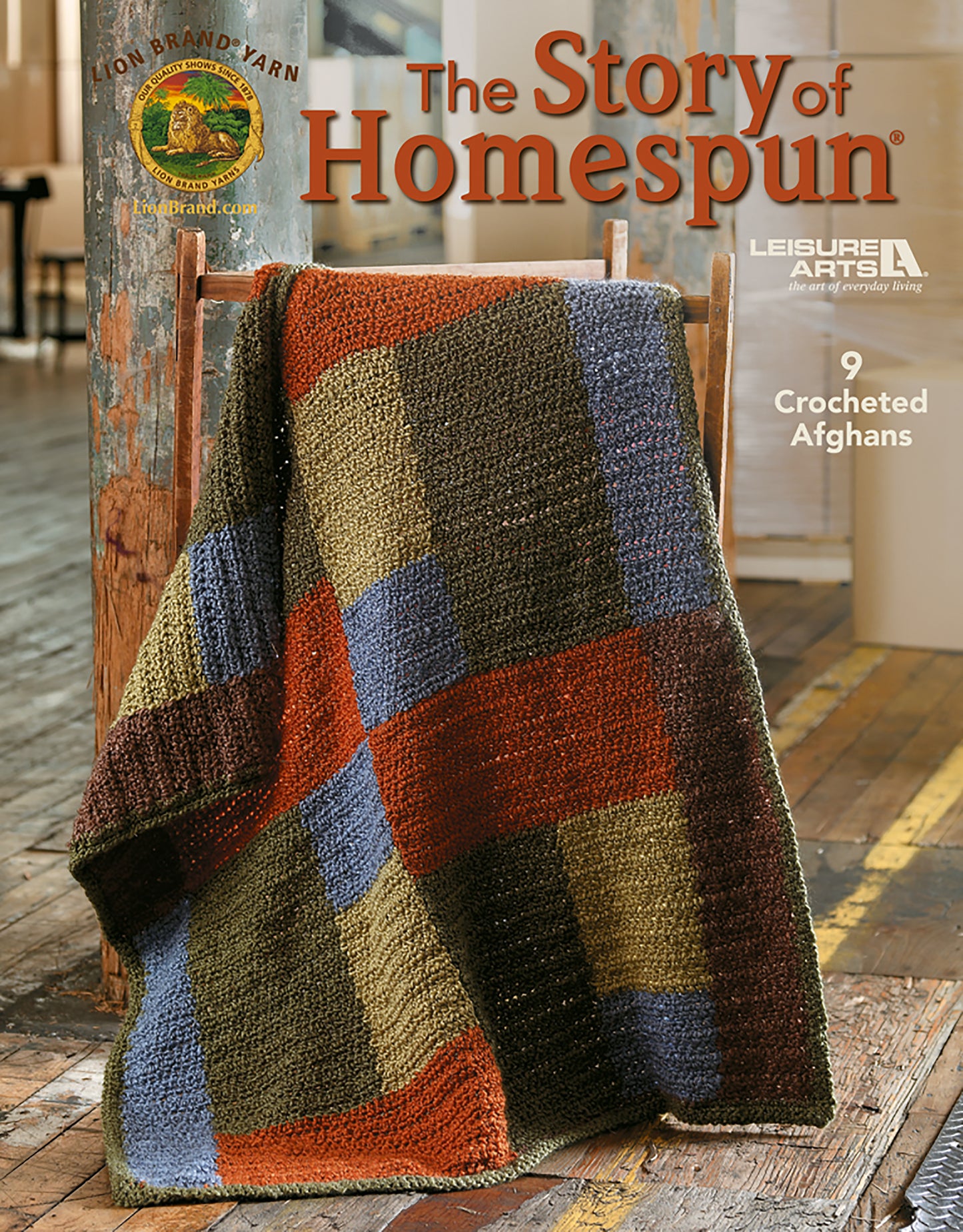 A bulky multicolored afghan in green, blue, brown, and red drapes over a chair in a rustic room. The cover reads "The Story of Homespun Crochet" by Leisure Arts, featuring 9 crocheted afghan patterns.