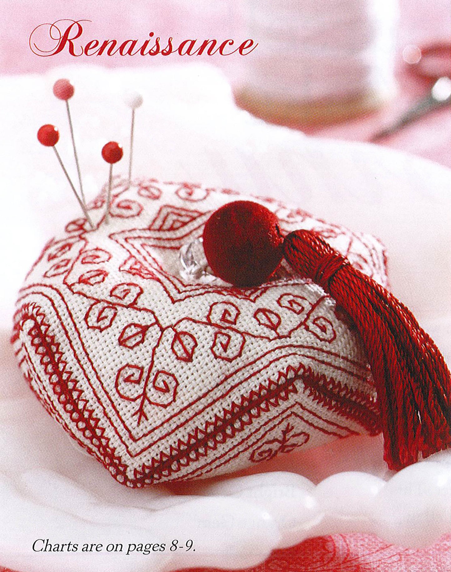 The Leisure Arts "Teach Yourself to Make Biscornu" digital download features a decorative pincushion with red and white geometric embroidery, adorned with a red tassel and pins. "Renaissance" appears above; charts are on pages 8–9.