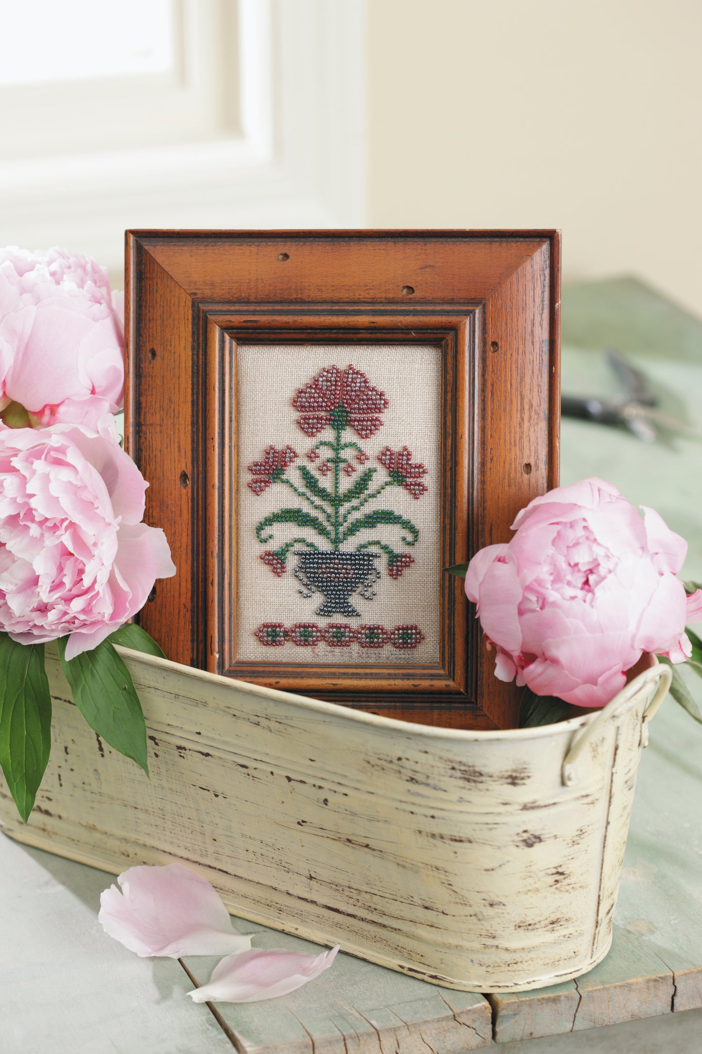 The "Stitch a Beaded Garden—18 Designs Charted for Beading and Cross Stitch" digital download by Leisure Arts features vibrant floral motifs enhanced with seed beads, perfect for creating eye-catching displays in your home.