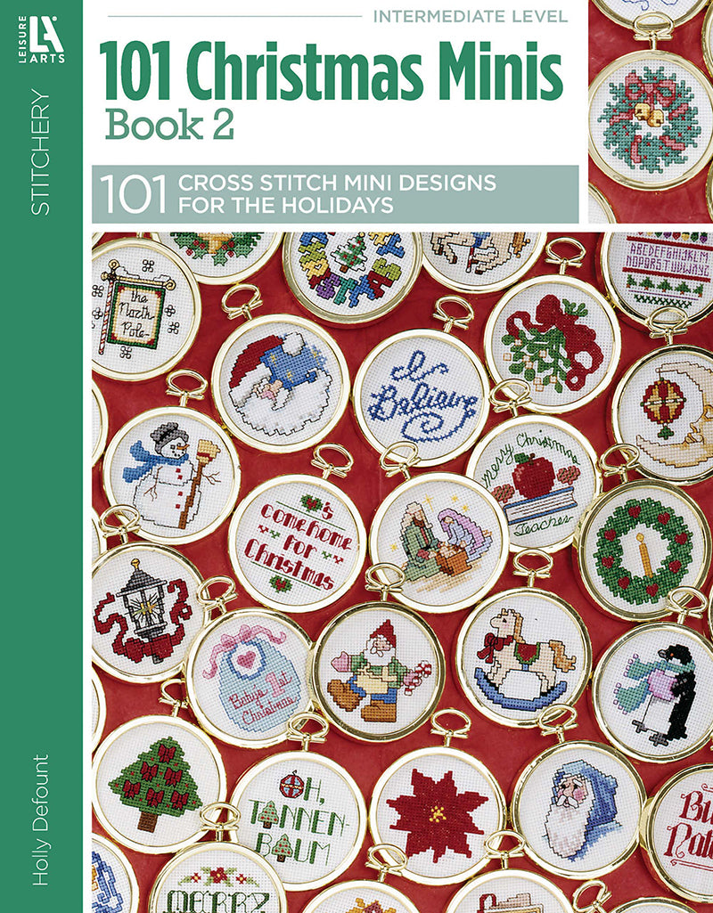 Cover of Leisure Arts’ 101 Christmas Minis Book 2 showcases festive ornament cross stitch designs—Santa, Christmas trees, greetings—arranged on a bright red background.