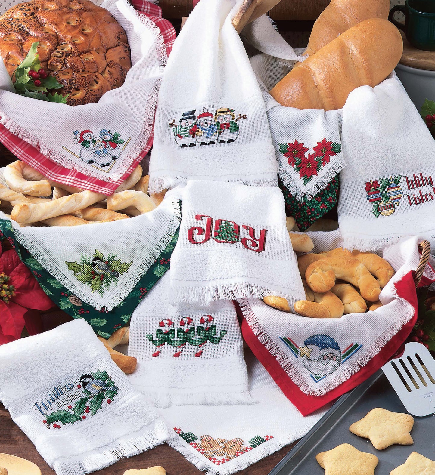 Display your holiday treats with Christmas Towels & Bread Cloths from Leisure Arts—festive embroidered napkins featuring snowmen, angels, poinsettias, and holly, perfect for Christmas decor and seasonal baking.