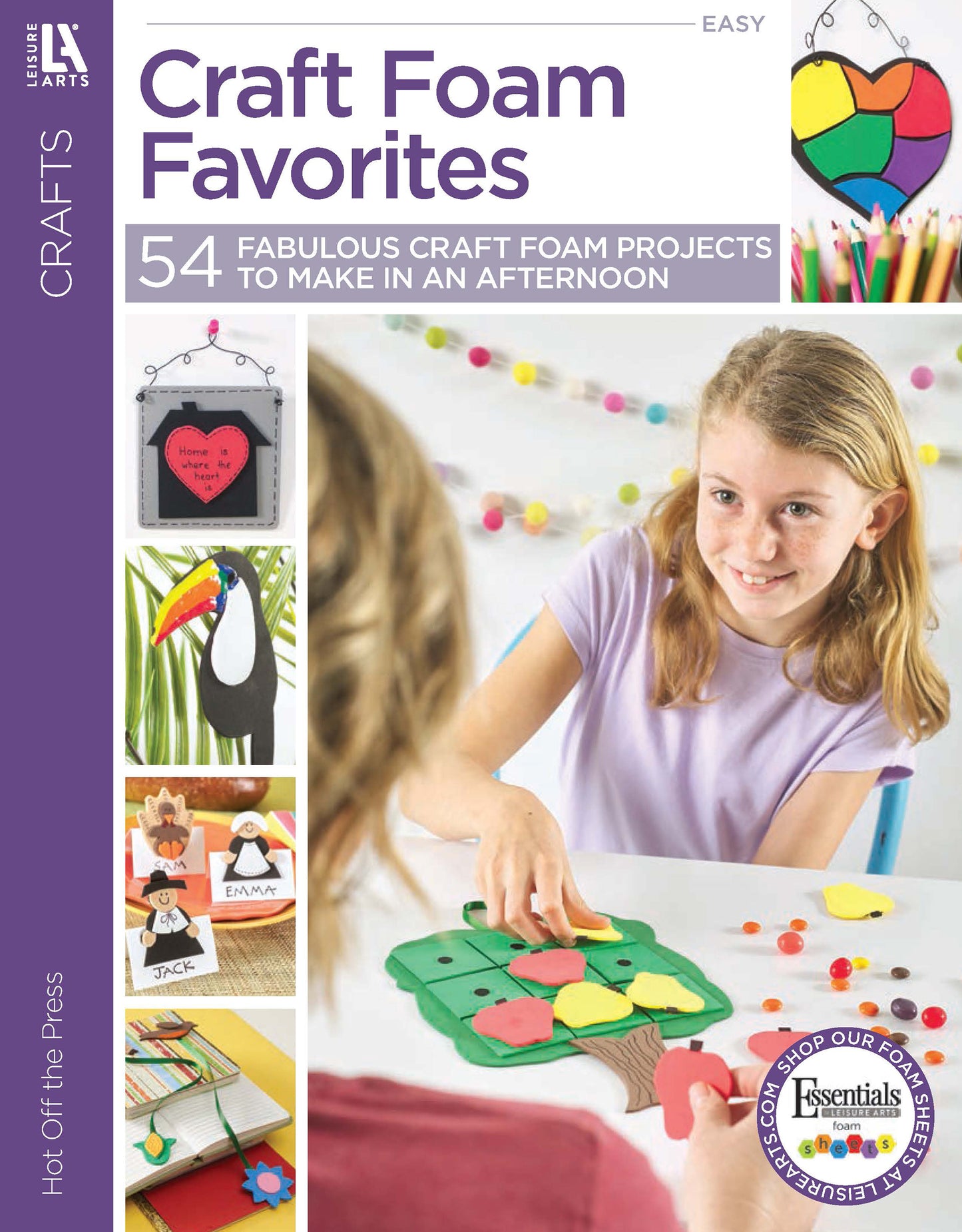 A young girl assembles a colorful foam tree from Craft Foam Favorites by Leisure Arts. The magazine features vibrant craft foam DIYs—animal figures, wall hangings, and more—with text promoting 54 fabulous kids crafts.