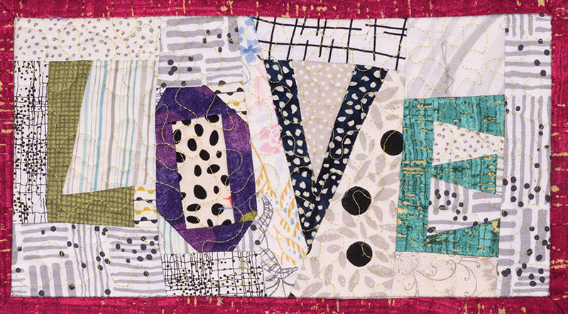 Quilt Small, Dream Big" by C&T Publishing is a vibrant quilted art piece spelling LOVE in varied colors and patterns, bordered in pink and featuring abstract designs and polka dots, highlighting miniature piecing techniques.