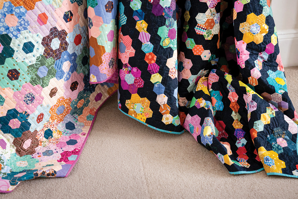Two 50 Hexagon Quilts made of multicolored fabric patches draped over a surface.