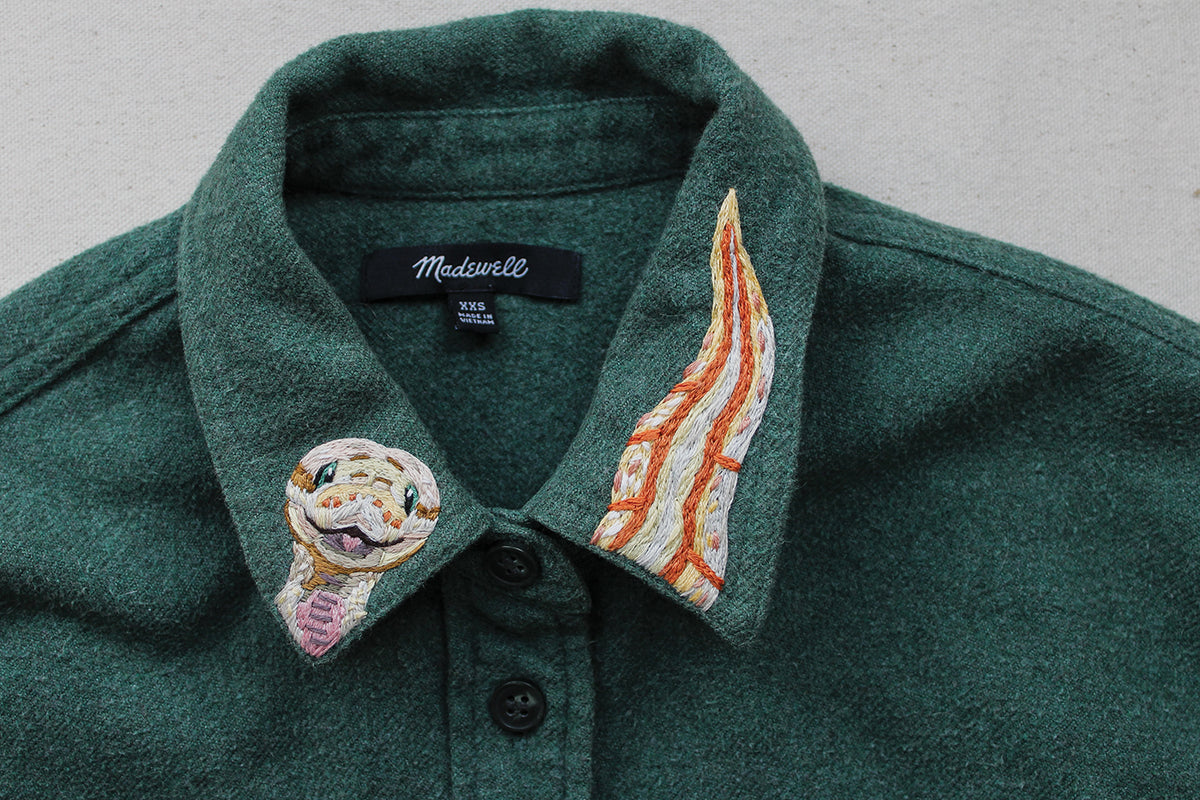 Green Wild & Wearable Animal Embroidery collared shirt featuring a snake head on the left collar point and a matching snake tail on the right.