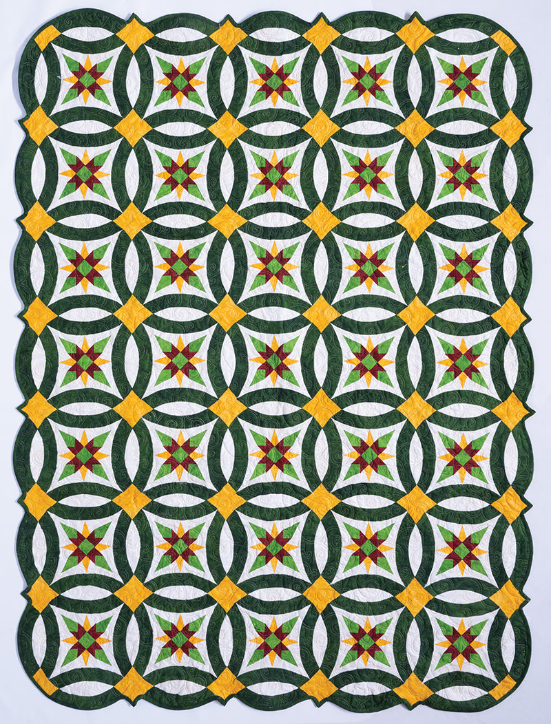 The Elm Creek Quilts Christmas Eco Tote by C&T Publishing features interlocking green and white rings, yellow diamonds, and red and yellow stars, framed by scalloped edges—a festive, stylish tote inspired by classic quilt designs.