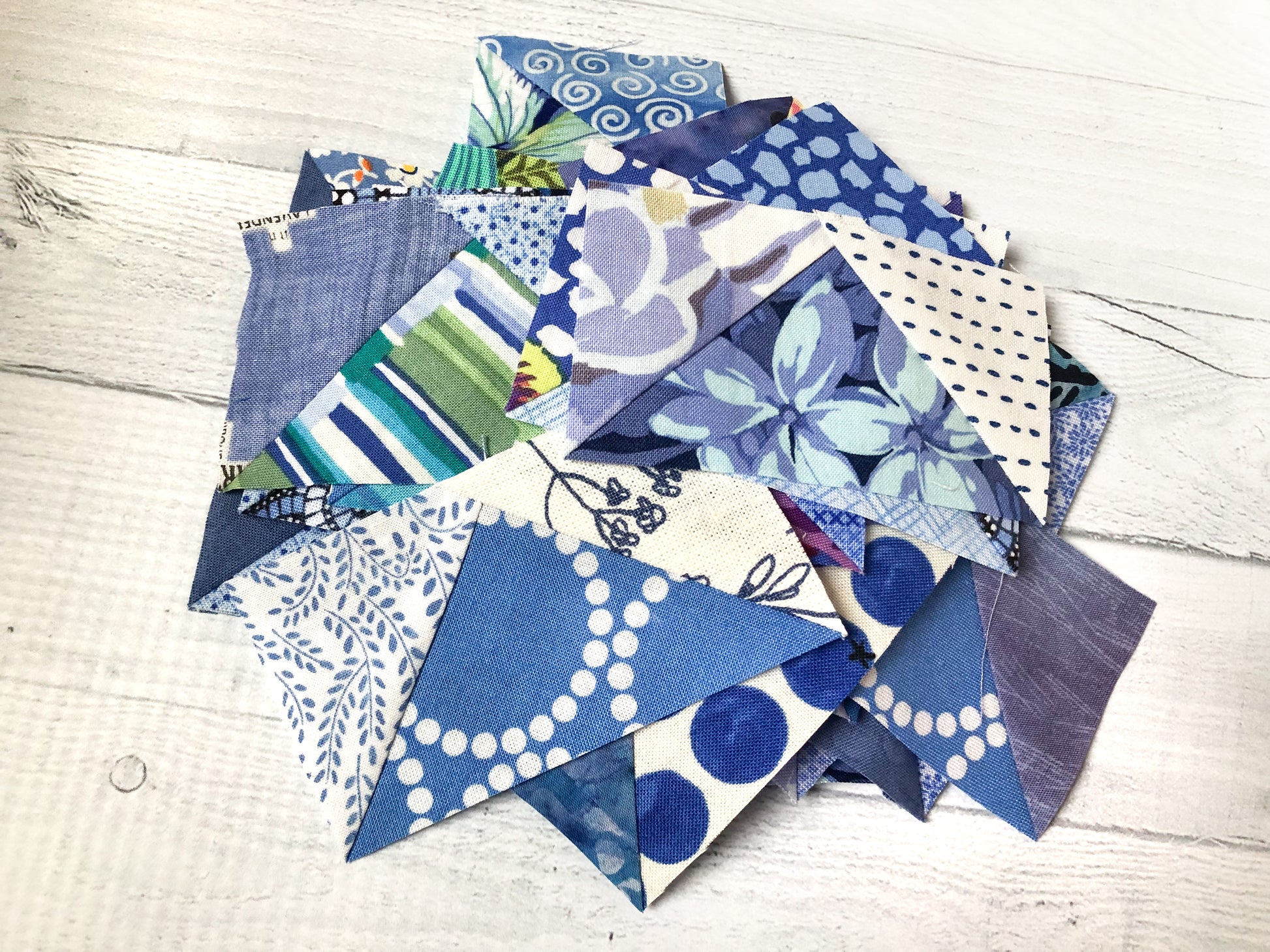 A selection of blue and white quilt pieces with florals, polka dots, stripes, and swirls—ideal for showcasing color choices using The Misunderstood Quilt: Blend Color, Value & Precision by Creative Spark.